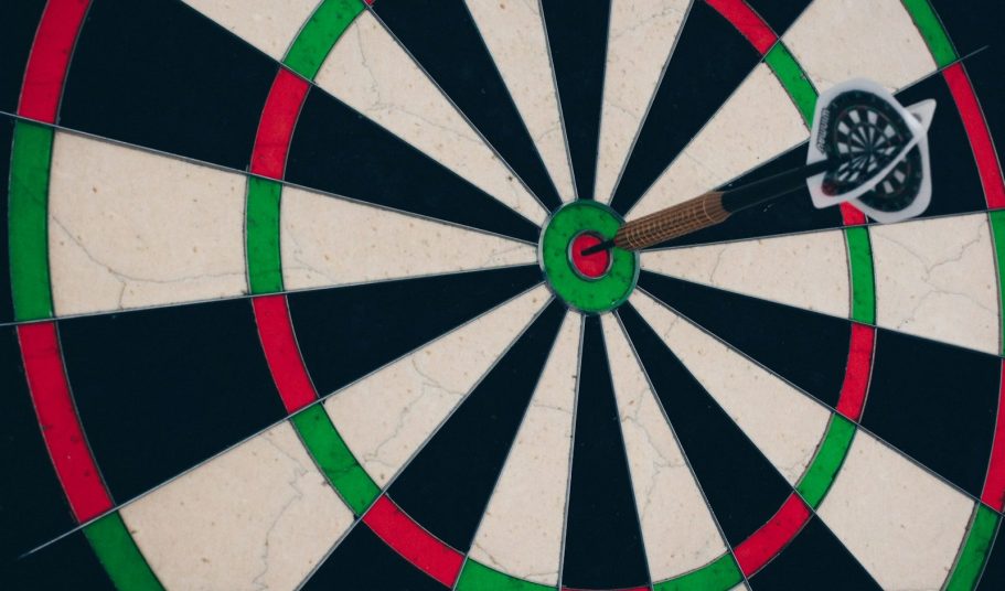 Zielscheibe mit Pfeil im Zentrum, umgeben von roten und grünen Ringen.