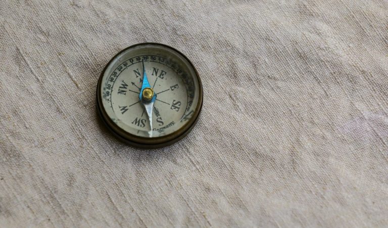 Ein Kompass auf einem weichen, hellen Untergrund.