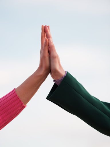 Hände zweier Personen berühren sich in einer Haltung des Einvernehmens.